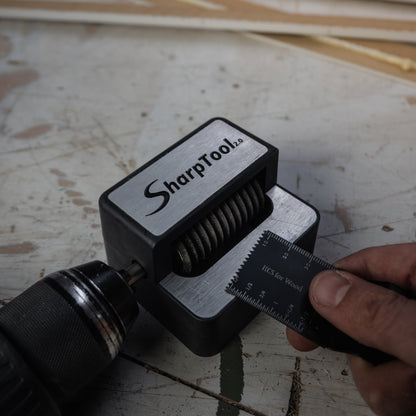 Gebruiker die een multitoolblad in de SharpTool 2.0 plaatst om te slijpen met een boormachine